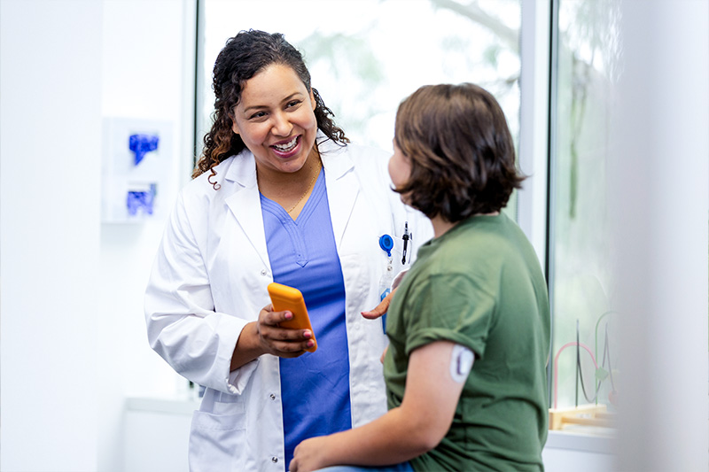 Woman and female physician speaking about HbA1c diabetic monitoring in an office setting.